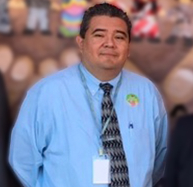 Picture of Marcus Alonzo who has short brown hair and is wearing a blue button down shirt and tie.